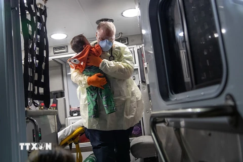 Nhân viên y tế chuyển bệnh nhi có triệu chứng sốt từ xe cứu thương vào một bệnh viện ở bang Connecticut, Mỹ ngày 4/4/2020 trong bối cảnh dịch COVID-19 lây lan mạnh. (Nguồn: Getty Images/TTXVN)