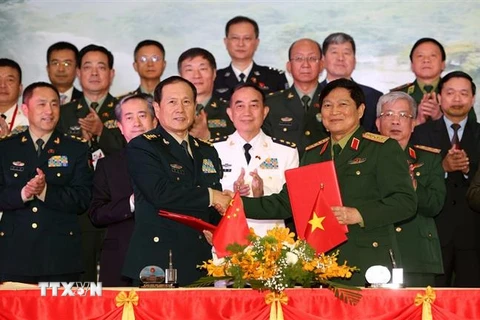 Đại tướng Ngô Xuân Lịch và Thượng tướng Ngụy Phượng Hòa ký Biên bản giao lưu. (Ảnh: Dương Giang/TTXVN)