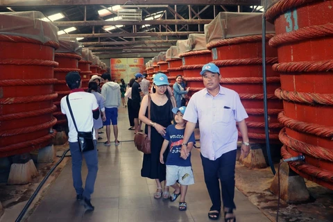 Khách du lịch tham quan khu sản xuất nước mắm tại Nhà thùng nước mắm Khải Hoàn trên đảo Phú Quốc (Kiên Giang). (Ảnh: Lê Huy Hải/TTXVN)