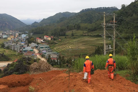 Công nhân Công ty Điện lực Hà Giang lắp đặt công tơ cho khách hàng trên địa bàn huyện Đồng Văn. (Ảnh: Ngọc Hà/TTXVN)