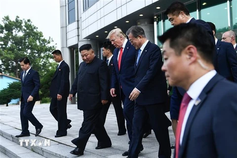 Nhà lãnh đạo Triều Tiên Kim Jong-un (thứ 3, trái) và Tổng thống Mỹ Donald Trump (giữa) sau cuộc gặp ở làng đình chiến Panmunjom tại Khu phi quân sự (DMZ) chiều 30/6/2019. (Ảnh: AFP/TTXVN)