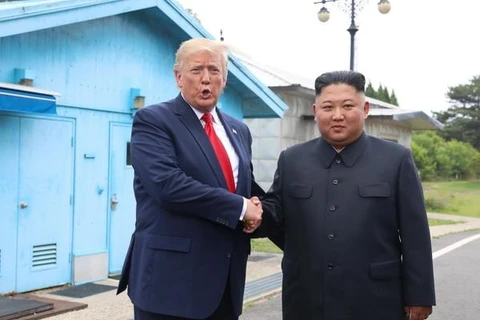 Tổng thống Mỹ Donald Trump (trái) và nhà lãnh đạo Triều Tiên Kim Jong-un trong cuộc gặp ở làng đình chiến Panmunjom tại Khu phi quân sự (DMZ) chiều 30/6/2019. (Ảnh: AFP/TTXVN)