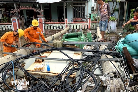 Công nhân điện lực nỗ lực khắc phục hậu quả bão số 5 để cấp điện cho người dân. (Ảnh: Tường Vi/TTXVN)