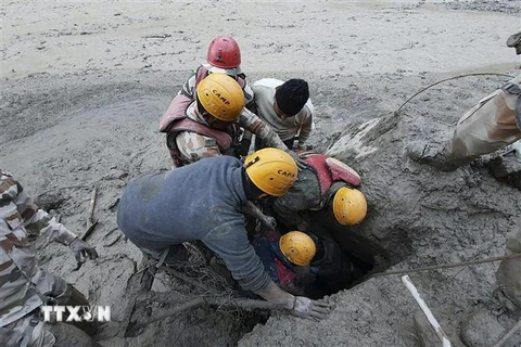 Lực lượng cứu hộ tìm kiếm nạn nhân tại khu vực bị ảnh hưởng bởi trận lũ quét ở bang Uttarakhand, Ấn Độ do vỡ sông băng trên dãy Himalaya, ngày 7/2/2021. (Ảnh: AFP/TTXVN)