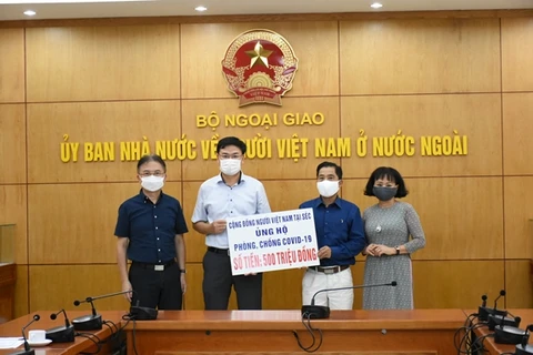 Thứ trưởng Phạm Quang Hiệu tiếp nhận số tiền 500 triệu đồng của kiều bào Việt Nam tại Séc ủng hộ Quỹ vaccine phòng, chống Covid-19. (Ảnh: Qdnd.vn)