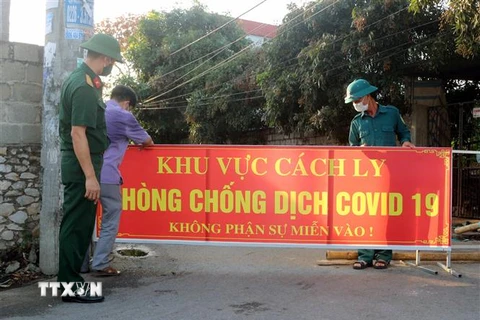 Lực lượng chức năng của tỉnh Hà Nam tiến hành lập chốt phong tỏa thôn 4, xã Thi Sơn, huyện Kim Bảng. (Ảnh: Nguyễn Chinh/TTXVN)