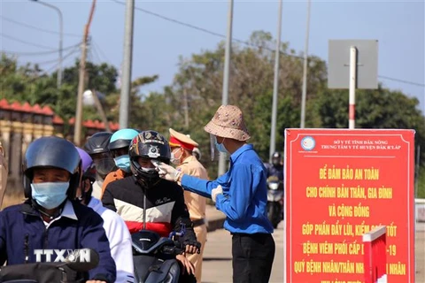 Đo thân nhiệt người dân để sàn lọc, phòng chống dịch COVID-19 tại Đắk Nông. (Ảnh: Hưng Thịnh/TTXVN)