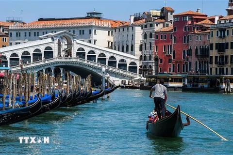 Khách du lịch đi thuyền gondola tại Venice, Italy, ngày 12/6/2020. (Ảnh: AFP/ TTXVN)