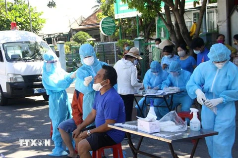 Lực lượng Y tế lấy mẫu test nhanh cho người dân trong khu vực nhà bệnh nhân sinh sống. (Ảnh: Phước Tuệ/TTXVN)