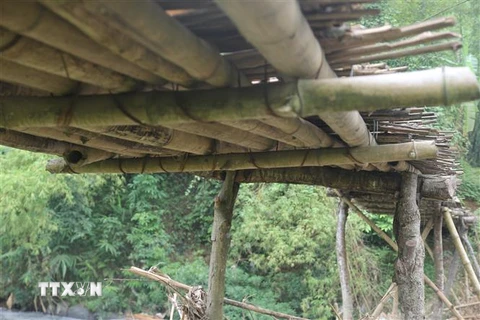 Cầu làm tạm bợ từ tre nứa, rất nguy hiểm cho người dân qua lại. (Ảnh: Nguyễn Việt Dũng/TTXVN)