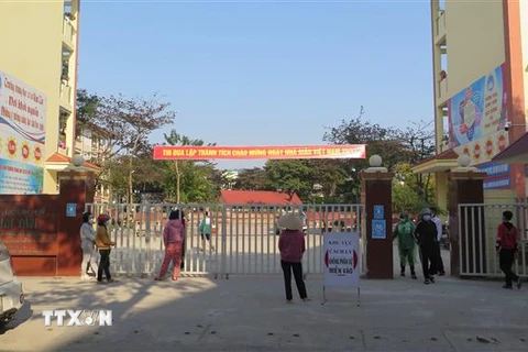 Phụ huynh Trường THCS Kim Tân, thành phố Lào Cai ở ngoài cổng trường đợi con em mình lấy mẫu xét nghiệm COVID-19. (Ảnh: TTXVN/phát)