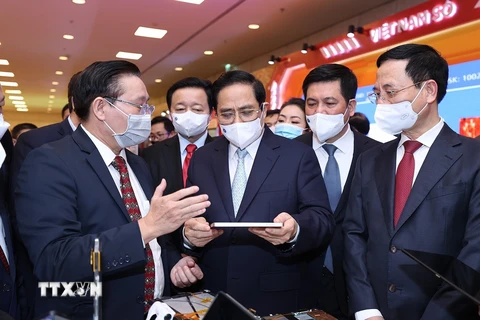 Thủ tướng Phạm Minh Chính tham quan gian trưng bày sản phẩm công nghệ số của các doanh nghiệp tham dự Diễn đàn. (Ảnh: Dương Giang/TTXVN)