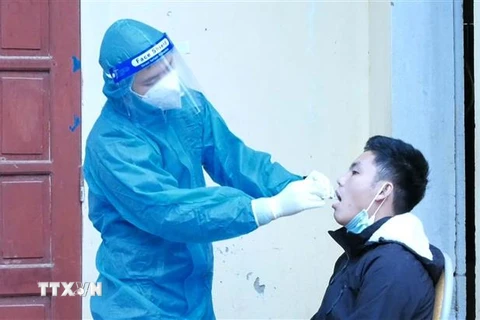 Nhân viên y tế lấy mẫu xét nghiệm COVID-19 cho người dân ở huyện miền núi Lang Chánh. (Ảnh: Nguyễn Nam/TTXVN)