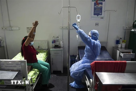 Nhân viên y tế hỗ trợ bệnh nhân COVID-19 tập luyện sau khi hồi phục tại bệnh viện ở Sullana, Piura, miền Bắc Peru. (Ảnh: AFP/TTXVN)