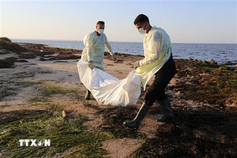 Nhân viên Cơ quan bảo vệ dân sự Tunisia chuyển thi thể người di cư thiệt mạng do chìm thuyền tại Zarzis, ngày 16/7/2019. (Ảnh: AFP/TTXVN)