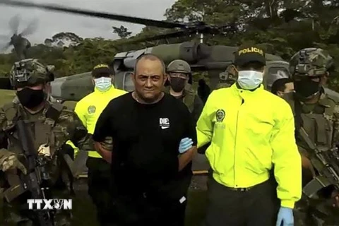 Binh sỹ và cảnh sát Colombia áp giải đối tượng Dairo Antonio Usuga (giữa) tại Bogota ngày 23/10/2021. (Ảnh: AFP/ TTXVN)