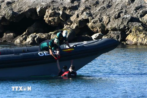 Lực lượng vệ binh dân sự Tây Ban Nha cứu một người di cư lên thuyền, sau khi người này vượt biển từ Maroc sang Ceuta, Tây Ban Nha, ngày 17/5/2021. (Ảnh: AFP/ TTXVN)