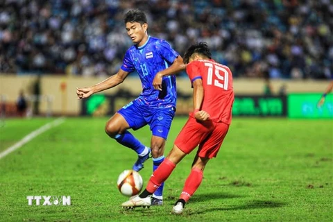 Cầu thủ U23 Thái Lan Teerasak Poeiphimai (số 13) cản đường lên bóng của cầu thủU23 Lào. (Ảnh: Tuấn Anh/TTXVN)