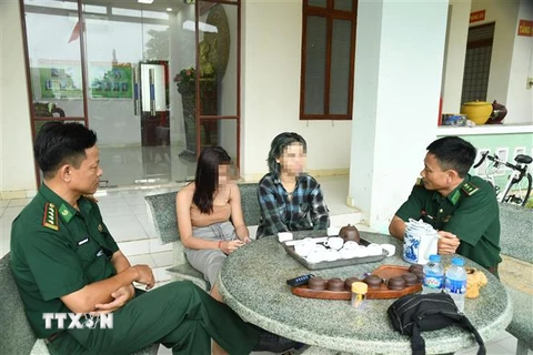 Lực lượng Bộ đội Biên phòng tỉnh Tây Ninh nghe hai nữ nạn nhân kể lại sự việc sau khi được giải cứu. (Ảnh: TTXVN phát)