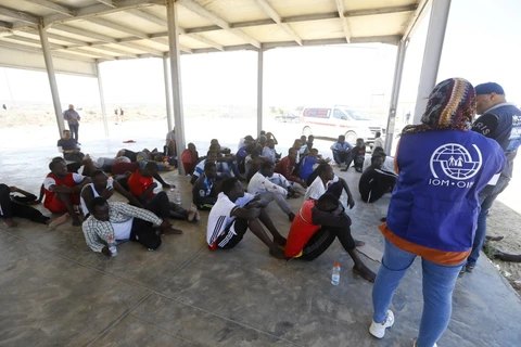 Người di cư tập trung tại một điểm kiểm soát của lực lượng bảo vệ bờ biển Libya. (Ảnh: AFP/ TTXVN)