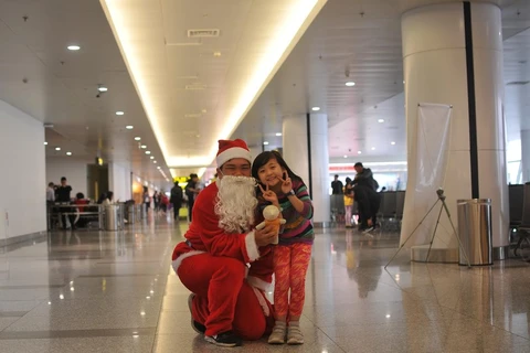 Biểu cảm dễ thương của hành khách nhí khi nhận được quà tặng từ Ông già Noel mà Cảng hàng không Nội Bài chuẩn bị chu đáo để khách có một Giáng sinh ấm áp, an lành. (Ảnh: CTV/Vietnam+)