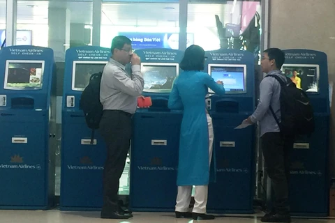 Hành khách làm dịch vụ thủ tục trực tuyến vé máy bay tại quầy Kios Vietnam Airlines ở một số sân bay. (Ảnh: Việt Hùng/Vietnam+)