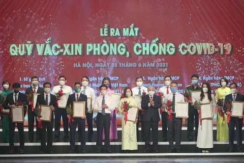 Đại diện các doanh nghiệp sau khi ủng hộ Quỹ Vắc xin phòng chống COVID-19. (Ảnh: CTV/Vietnam+)