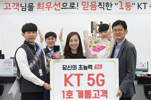 Khách hàng đầu tiên đăng ký sử dụng mạng 5G của nhà mạng KT, cô Lee Ji-eun (giữa), tại Daegu, Hàn Quốc, ngày 3/4/2019. (Ảnh: Yonhap/TTXVN)