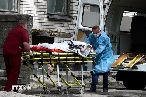 Chuyển bệnh nhân mắc COVID-19 từ xe cứu thương vào một bệnh viện ở Moskva, Nga. (Ảnh: AFP/TTXVN)