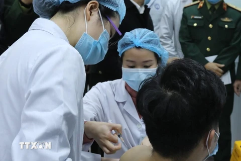 Sáng 17/12/2020, tại Học viện Quân y (Hà Nội), Bộ Y tế phối hợp với Bộ Quốc phòng, Bộ Khoa học và Công nghệ tổ chức tiêm thử nghiệm mũi vắcxin Nano Covax ngừa COVID-19 đầu tiên trên 3 người tình nguyện. (Ảnh: TTXVN)
