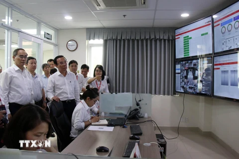 Bí thư Thành ủy Thành phố Hồ Chí Minh Nguyễn Văn Nên cùng đoàn lãnh đạo thành phố nghe giới thiệu về Trung tâm giám sát điều hành Công viên phần mềm Quang Trung. (Ảnh: Tiến Lực/TTXVN)