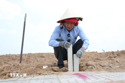 Cắm mốc nhằm xác định vị trí, diện tích các lô đất tại Khu tái định cư Lộc An-Bình Sơn. (Ảnh: Công Phong/TTXVN)