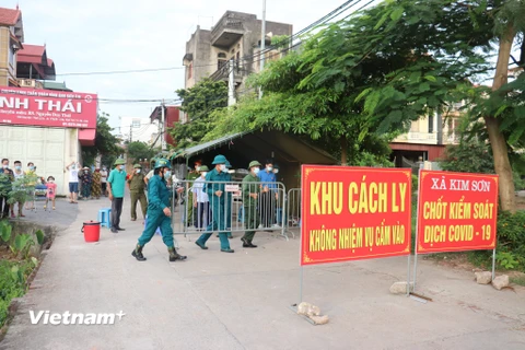 Lực lượng chức năng tháo dỡ chốt chặn hết thời gian cách ly tại 4 thôn của xã Kim Sơn. (Ảnh Mạnh Khánh/TTXVN)