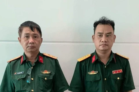 Võ Thành Phúc và Trần Vũ Hàn Minh Nhật (từ trái qua phải) tại cơ quan công an. (Nguồn: sggp.org.vn)
