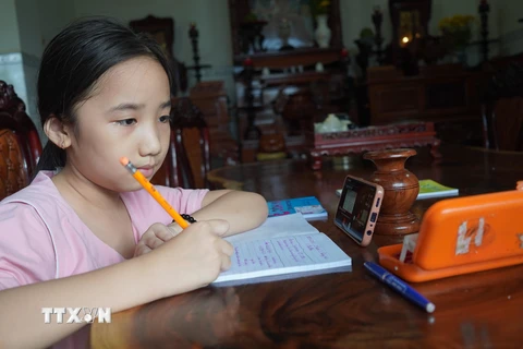 Dịch bệnh khiến các em học sinh không thể đến trường, phải học trực tuyến qua các thiết bị. (Ảnh: Thanh Tân/TTXVN)