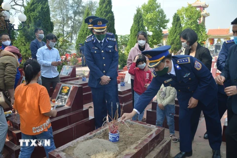 Chính quyền, đồng đội và gia đình đưa hài cốt Đại úy Phạm Văn Huy vào Nghĩa trang Liệt sỹ của xã Tiên Thanh. (Ảnh: TTXVN)