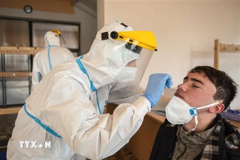 Nhân viên y tế lấy mẫu xét nghiệm COVID-19 tại Bohemia, CH Séc. (Ảnh: AFP/TTXVN)
