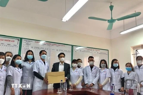 Phó Thủ tướng Vũ Đức Đam tặng quà cho cán bộ, nhân viên y tế Trạm y tế lưu động (cơ sở thu dung F0) tại Trường Mầm non xã Chu Phan (huyện Mê Linh). (Ảnh: Tuyết Mai/TTXVN)