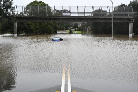 Một chiếc xe hơi bị bỏ lại trong nước lũ ở Lansvale, Tây Sydney ngày 3/7. (Ảnh: AAP)