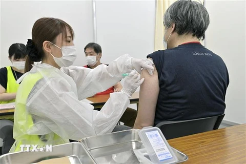 Nhân viên y tế tiêm chủng vaccine ngừa COVID-19 cho người dân tại Osaka, Nhật Bản. (Ảnh: Kyodo/TTXVN)