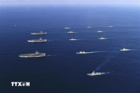 Tàu sân bay USS Ronald Reagan (trái, giữa), tàu USS Nimitz (trái, phía trên) và tàu USS Theodore Roosevelt của Mỹ tham gia tập trận hải quân chung với tàu khu trục của Hàn Quốc (giữa, phía trên và dưới) ở Biển Đông. (Ảnh: AFP/TTXVN)