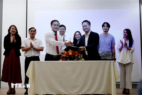 Đại diện EVN HCMC (bên trái) và MoMo ký kết hợp tác. (Ảnh: Thành Chung/TTXVN)