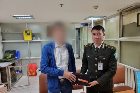 Anh Nguyễn Như Dương, nhân viên An ninh sân đỗ ôtô - Trung tâm An ninh hàng không Nội Bài - trao trả lại tài sản thất lạc cho hành khách. (Ảnh: NIA)
