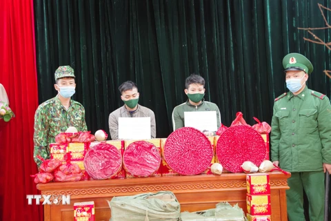 Hai đối tượng vận chuyển và số pháo trái phép bị thu giữ tại Lạng Sơn. (Ảnh: TTXVN phát)