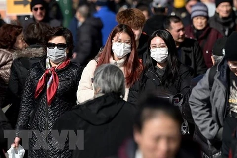 Người dân đeo khẩu trang để phòng tránh lây nhiễm COVID-19 tại New York, Mỹ. (Ảnh: AFP/TTXVN)