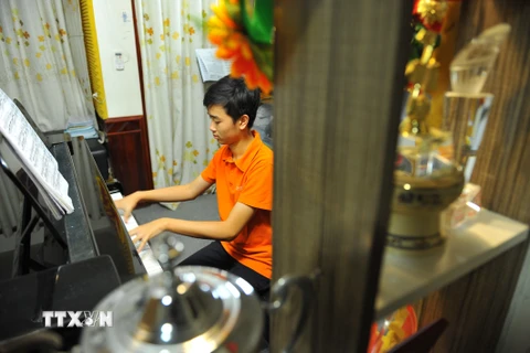 Võ Minh Quang luyện tập piano tại nhà. (Ảnh: Minh Đức/TTXVN)