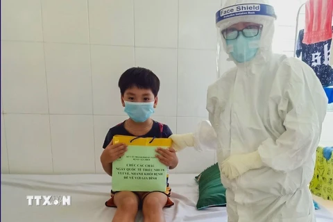 Nhân viên y tế Bệnh viện phổi Đà Nẵng trong trang phục bảo hộ y tế đến tặng quà cho các em thiếu nhi mắc COVID-19 đang điều trị tại bệnh viện. (Ảnh: TTXVN phát)