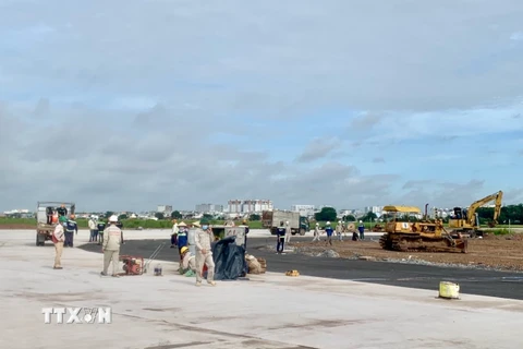 Công nhân thi công tại Dự án cải tạo, nâng cấp đường cất hạ cánh, đường lăn Cảng hàng không quốc tế Tân Sơn Nhất. (Ảnh: TTXVN phát) 