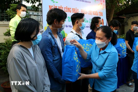 Chủ tịch Liên đoàn Lao động quận Gò Vấp Nguyễn Thị Bạch Yến tặng quà cho công nhân lao động có hoàn cảnh khó khăn không về quê đón Tết. (Ảnh: Thanh Vũ/TTXVN)