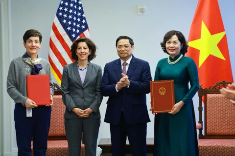 Thủ tướng Phạm Minh Chính và Bộ trưởng Thương mại Hoa Kỳ Gina Raimondo chứng kiến trao thoả thuận giữa Thống đốc Ngân hàng Nhà nước Nguyễn Thị Hồng và đại diện Công ty Tài chính quốc tế (IFC). (Ảnh: Dương Giang/TTXVN) 